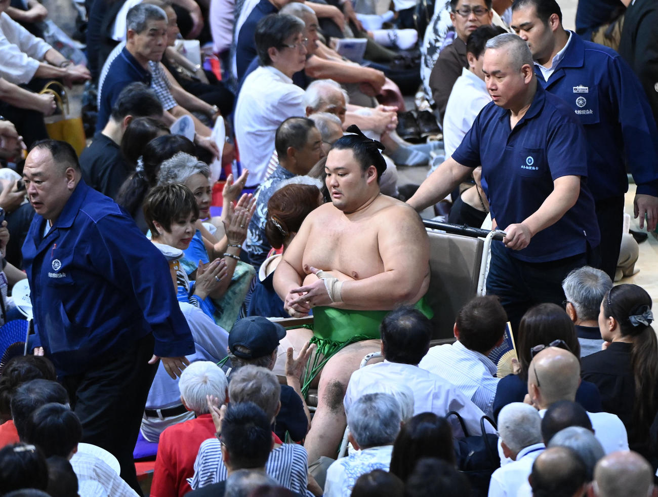 足を負傷し車椅子に乗せられ退場する朝乃山（中央）（撮影・森本幸一）