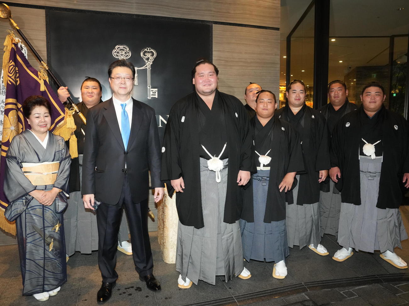 千秋楽パーティー会場で優勝の出迎えを受けた照ノ富士（中央）は、左からおかみの淳子さん、熱海富士、伊勢ケ浜親方、1人おいて宝富士、翠富士、錦富士、尊富士、伯桜鵬らと記念撮影する＝2024年7月28日