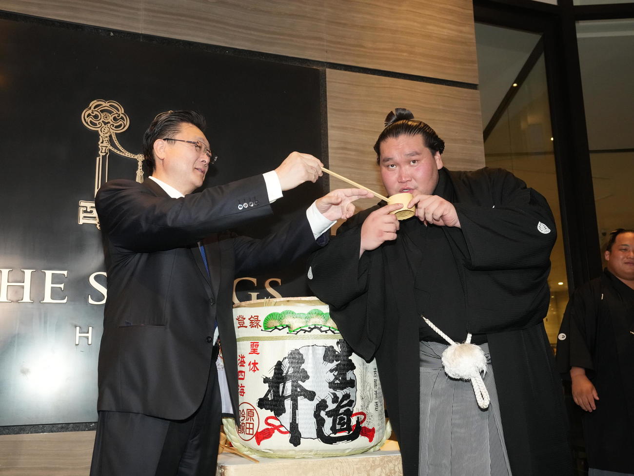 千秋楽パーティー会場で師匠の伊勢ケ浜親方（左）から水を付けてもらう照ノ富士（撮影・小沢裕）