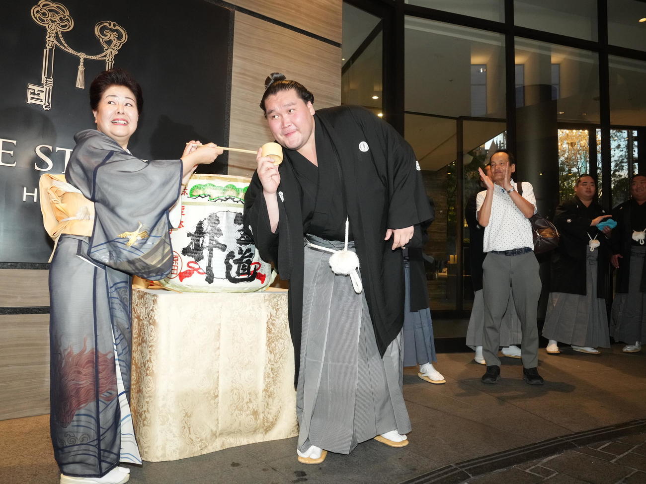 千秋楽パーティー会場でおかみの淳子さん（左）から水を付けてもらう照ノ富士（撮影・小沢裕）