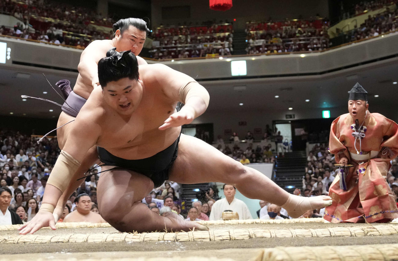 阿炎（手前）は翔猿に上手投げで敗れる。右は立行司に昇格した式守伊之助（撮影・小沢裕）