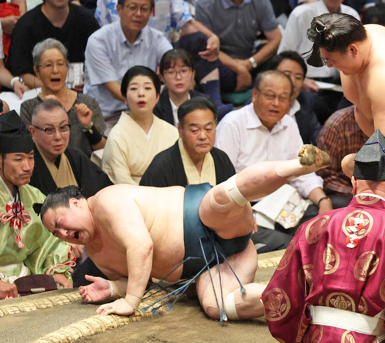 佐田の海（左）をはたき込みで破る欧勝馬。左から2人目は観戦する岩下尚史さん（撮影・中島郁夫）