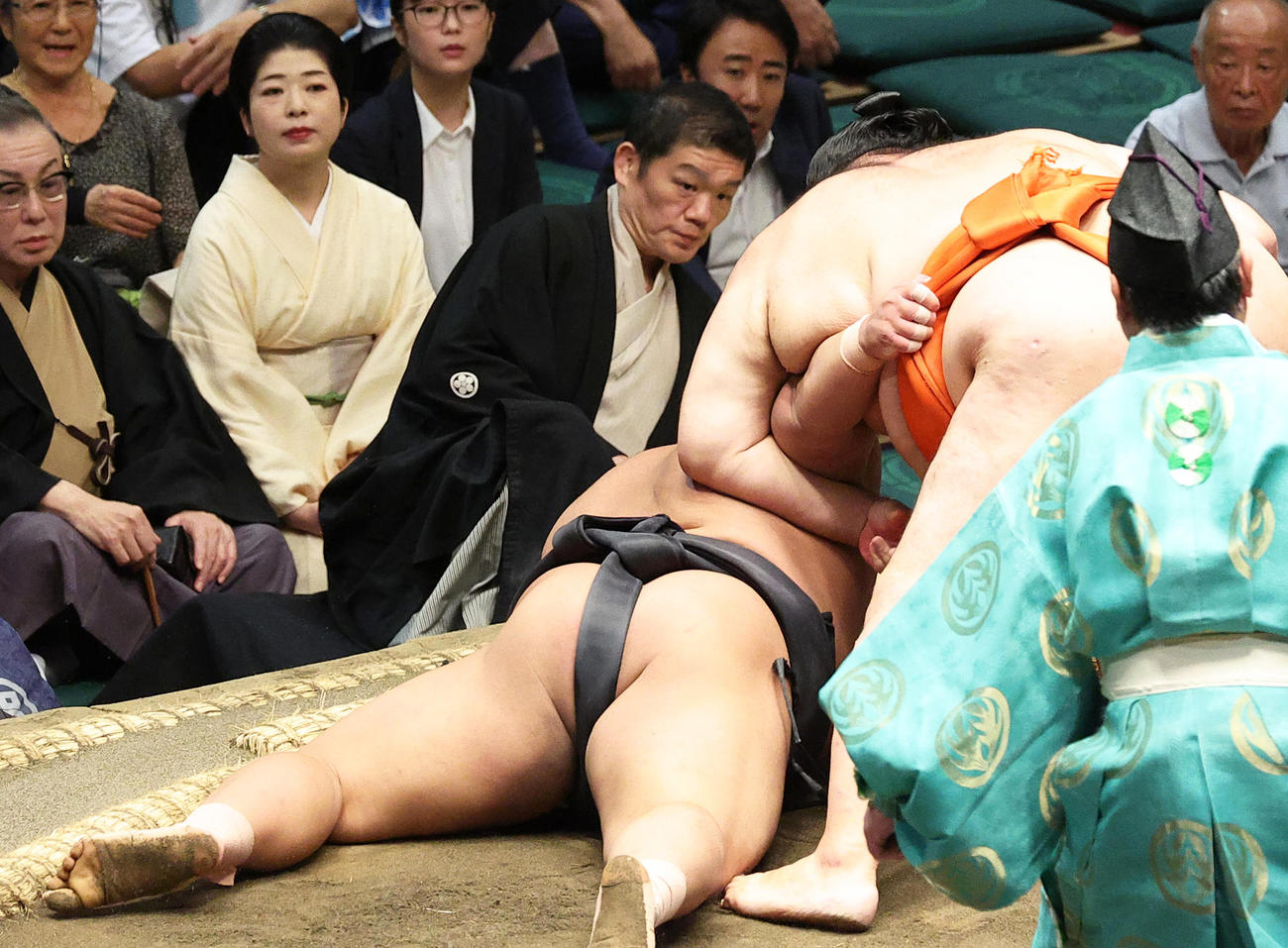 伯桜鵬（左）を小手投げで破る水戸龍。左端は観戦する岩下尚史さん（撮影・中島郁夫）
