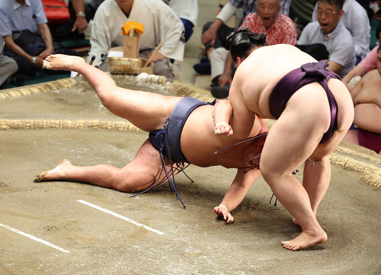豊昇龍（左）をすくい投げで破る王鵬（撮影・中島郁夫）