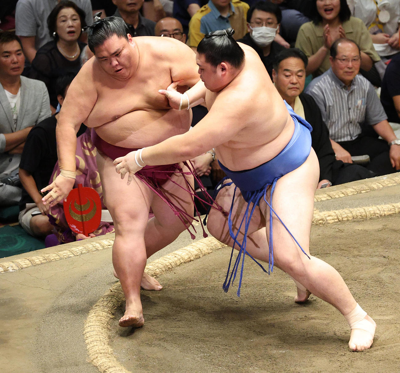御嶽海（左）を押し出しで破る大の里