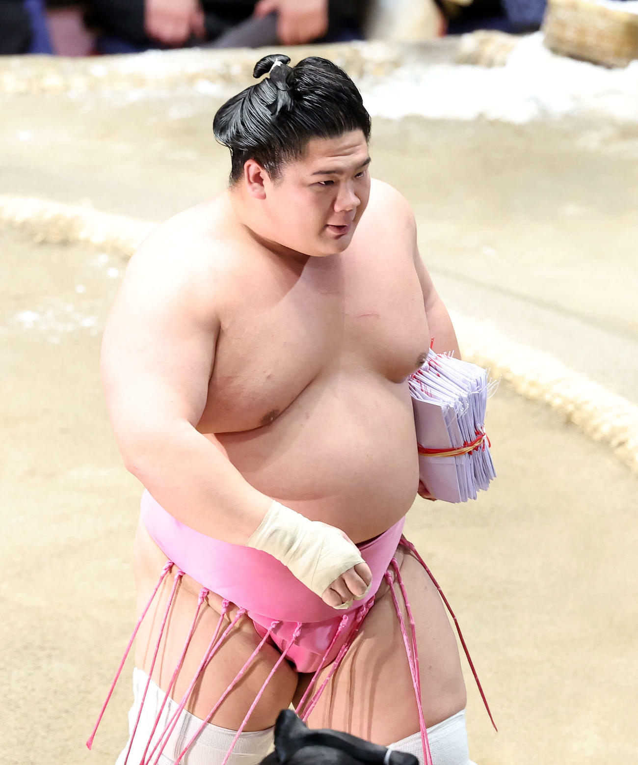 懸賞金の束を手に土俵を引き揚げる宇良（撮影・鈴木正人）