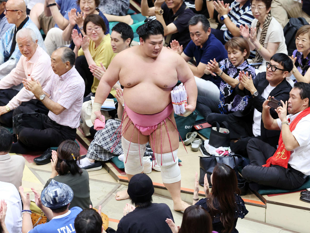 懸賞金の束を手に土俵を引き揚げる宇良（撮影・鈴木正人）