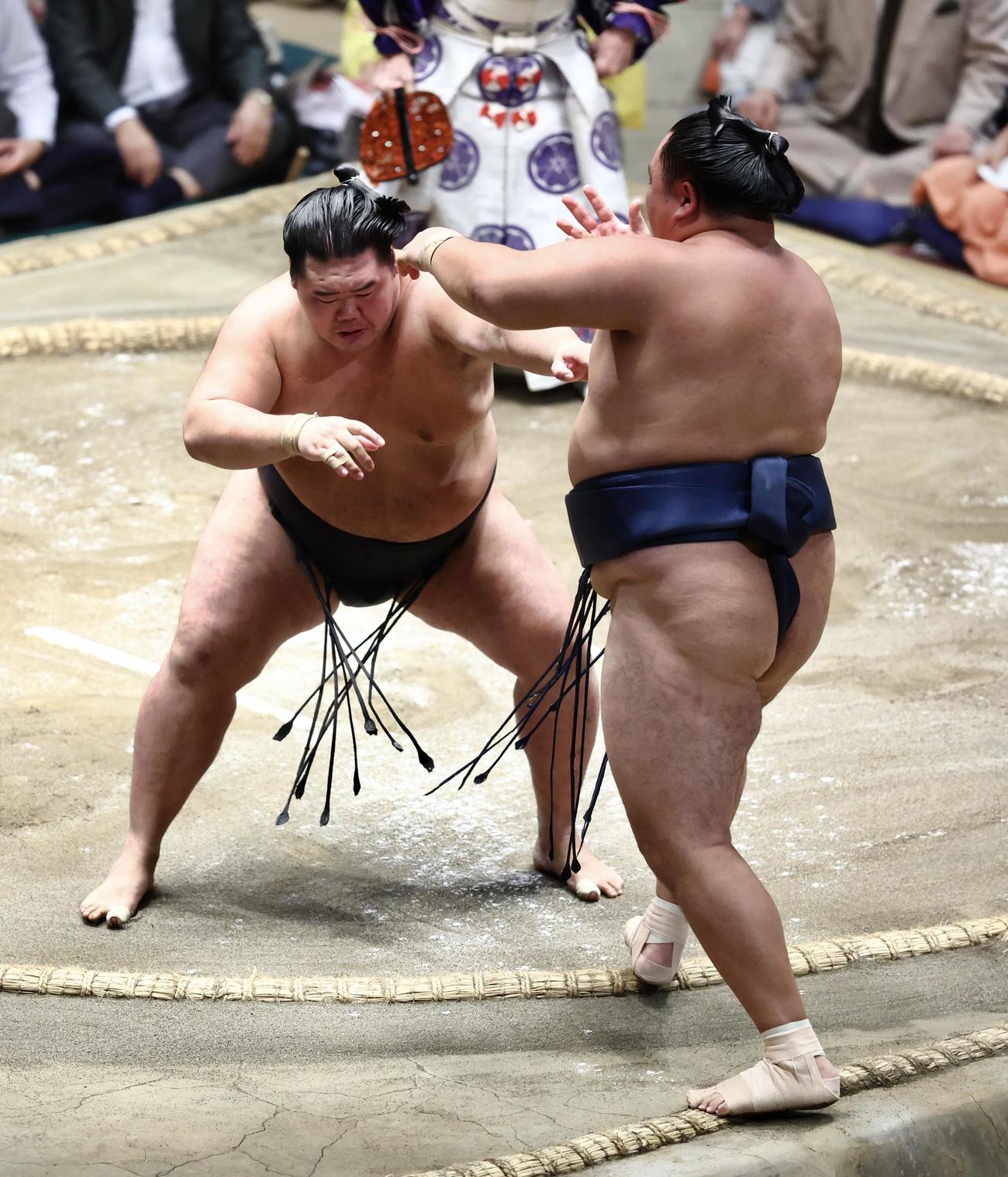 明生（左）は玉鷲を押し出しで破る（撮影・河田真司）