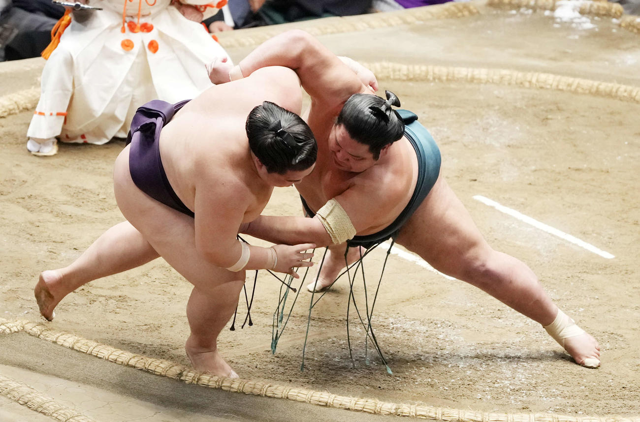 錦木（右）は寄り倒しで王鵬を破る（撮影・小沢裕）