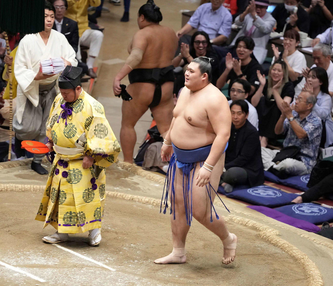 幕内優勝を決めた大の里は笑顔を見せる。左は立行司の木村庄之助（撮影・小沢裕）