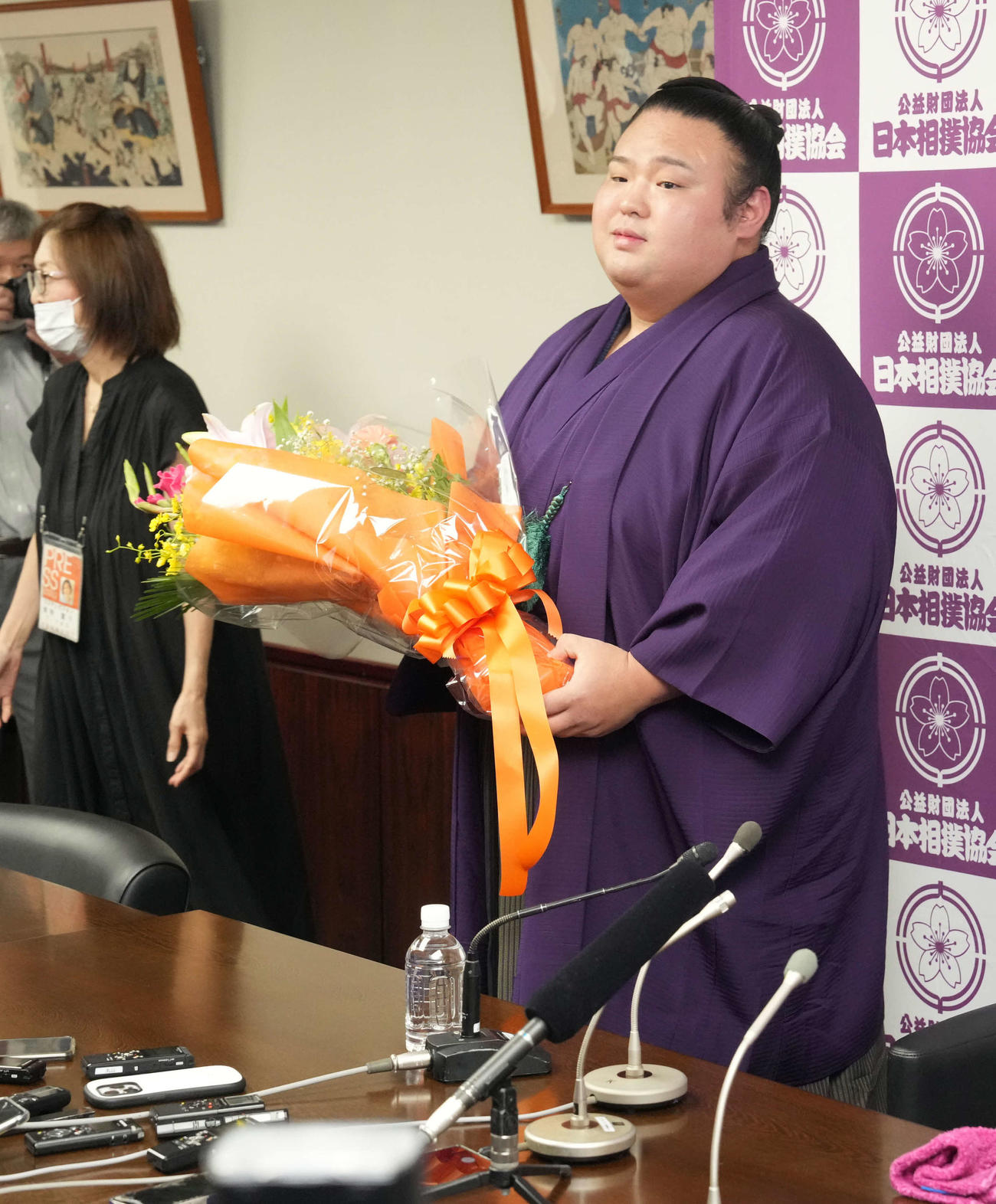 引退会見を終えた貴景勝は関係者から花束贈呈を受け、笑顔を見せる（撮影・小沢裕）