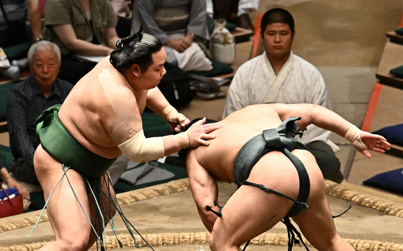 東白龍（左）は朝紅龍のまげをつかみ反則負けとなる（撮影・滝沢徹郎）