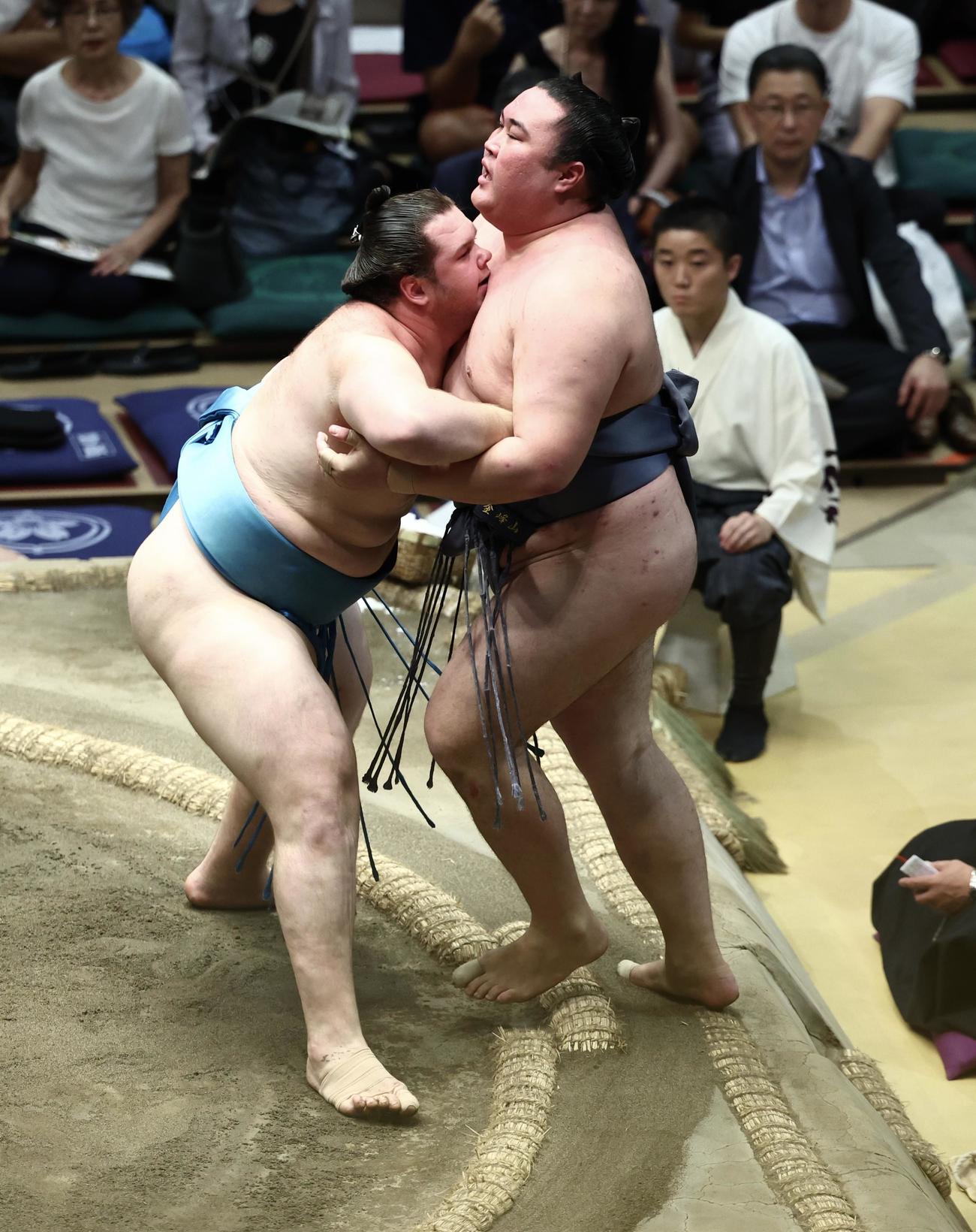 獅司（左）は金峰山を寄り切りで破る（撮影・河田真司）