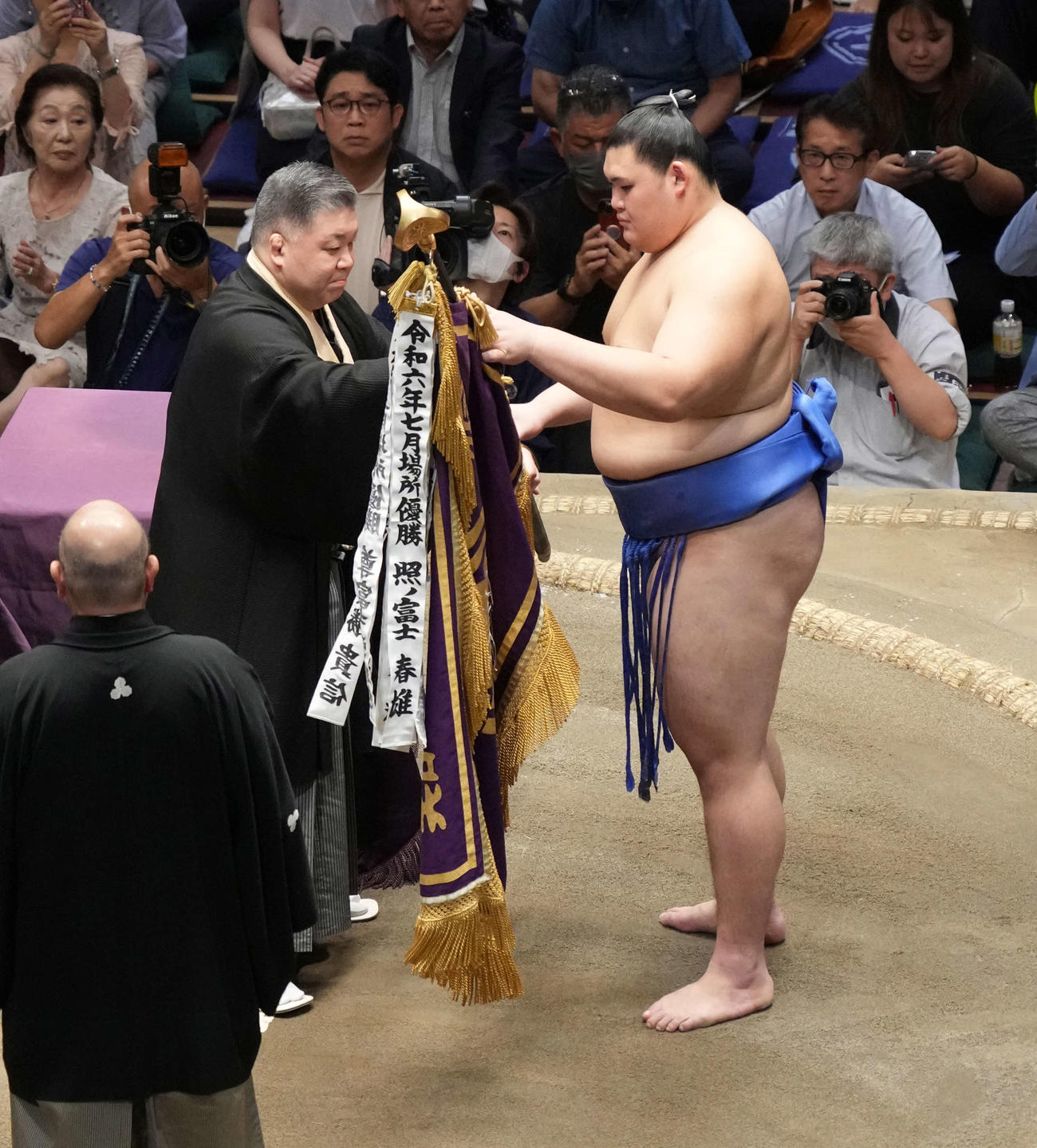 表彰式で高田川審判部長（左）から優勝旗を受け取る大の里（撮影・小沢裕）
