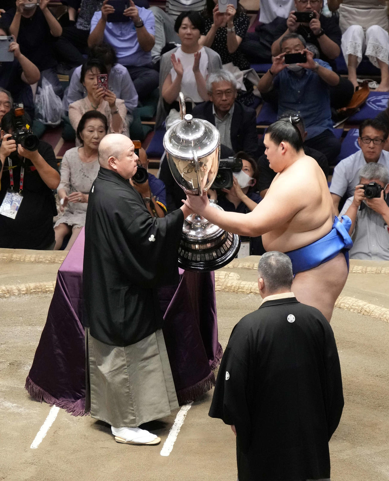 表彰式で八角理事長（左）から賜杯を贈呈される大の里（撮影・小沢裕）