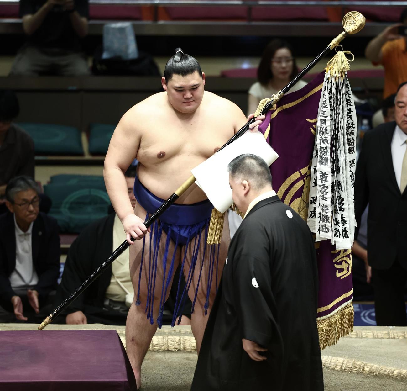 高田川審判部長（手前）から優勝旗を受け取る大の里（撮影・河田真司）