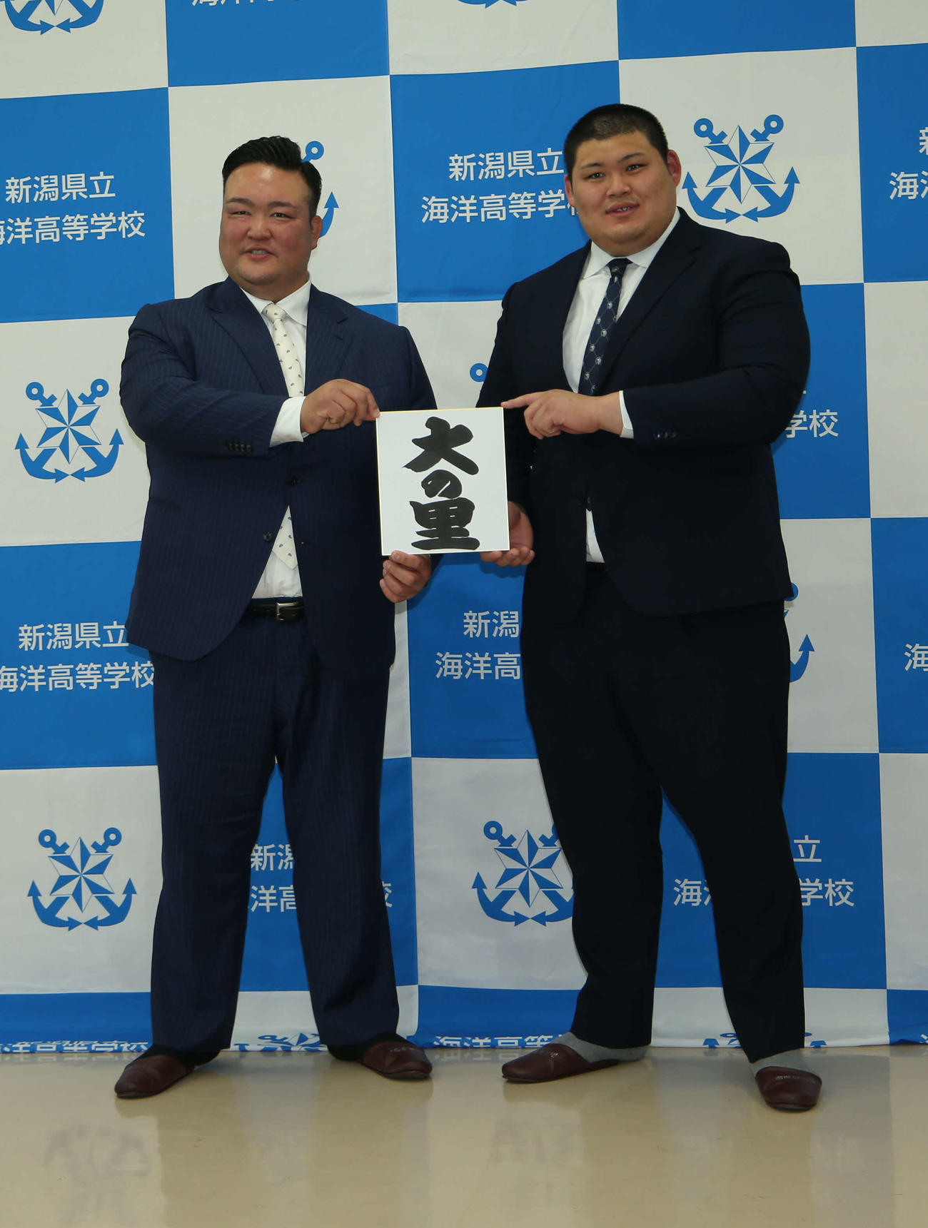 23年4月　しこ名を記した色紙を持つ二所ノ関親方（左）と中村
