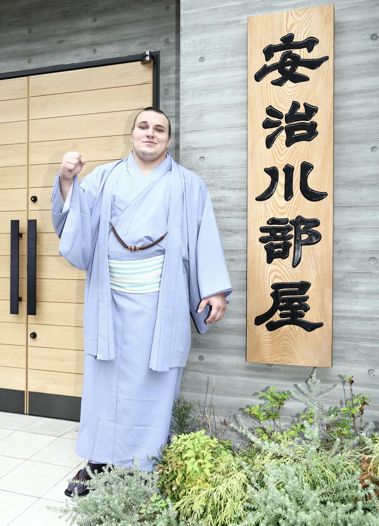 看板の前で写真に納まる新十両の安青錦（撮影・河田真司）
