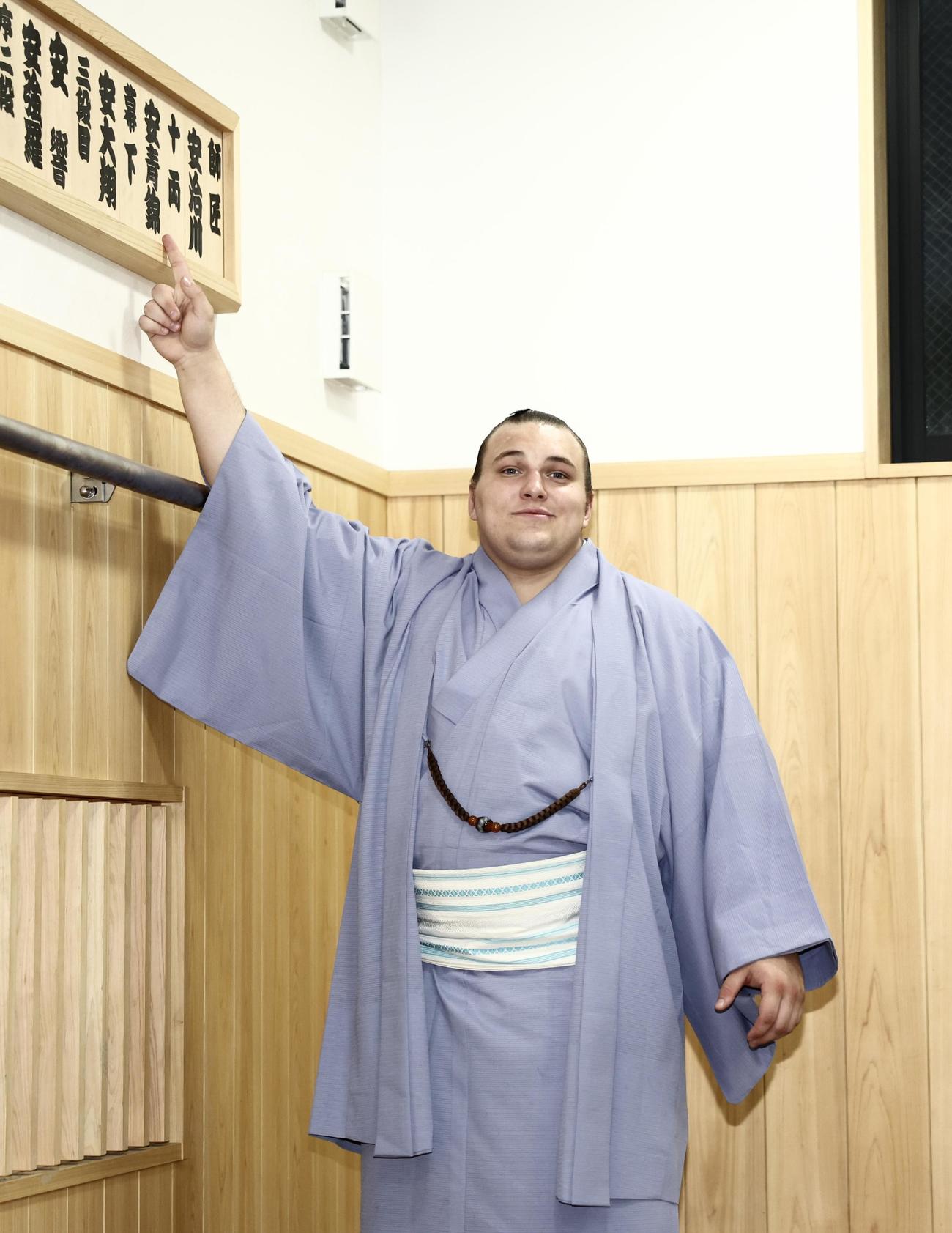 十両の場所に番付札を入れ替え、笑顔で指さす新十両の安青錦（撮影・河田真司）