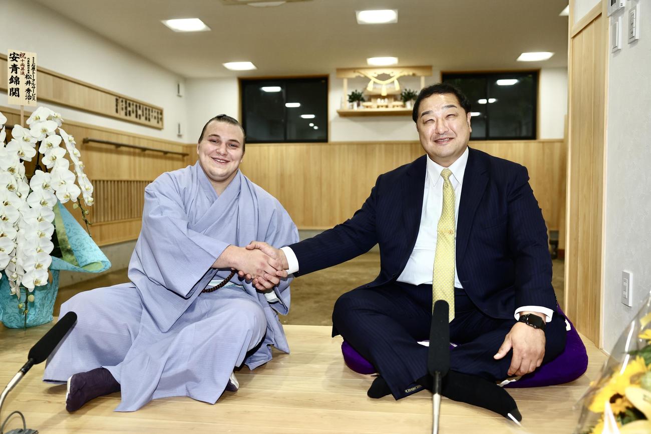 新十両に昇進した安青錦（左）は、安治川親方と笑顔で握手を交わす（撮影・河田真司）