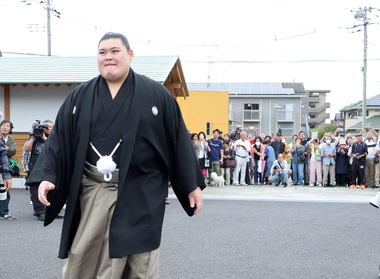 部屋前に集まったファンにあいさつし引き揚げる大の里（撮影・鈴木正人）