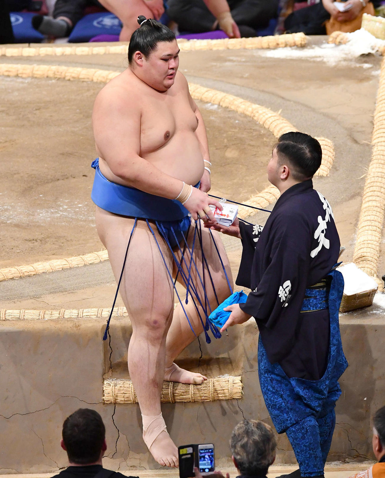 大相撲九州場所2日目　王鵬を押し倒しで破った大の里は、懸賞の束を手に土俵を下りる（撮影・岩下翔太）