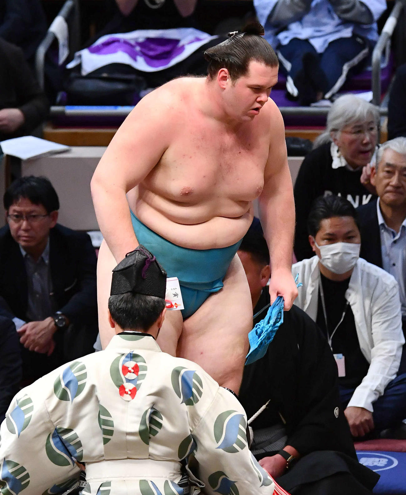 大相撲九州場所2日目　寄り切りで武将山を破り、懸賞を受け取って土俵を下りる獅司（撮影・岩下翔太）