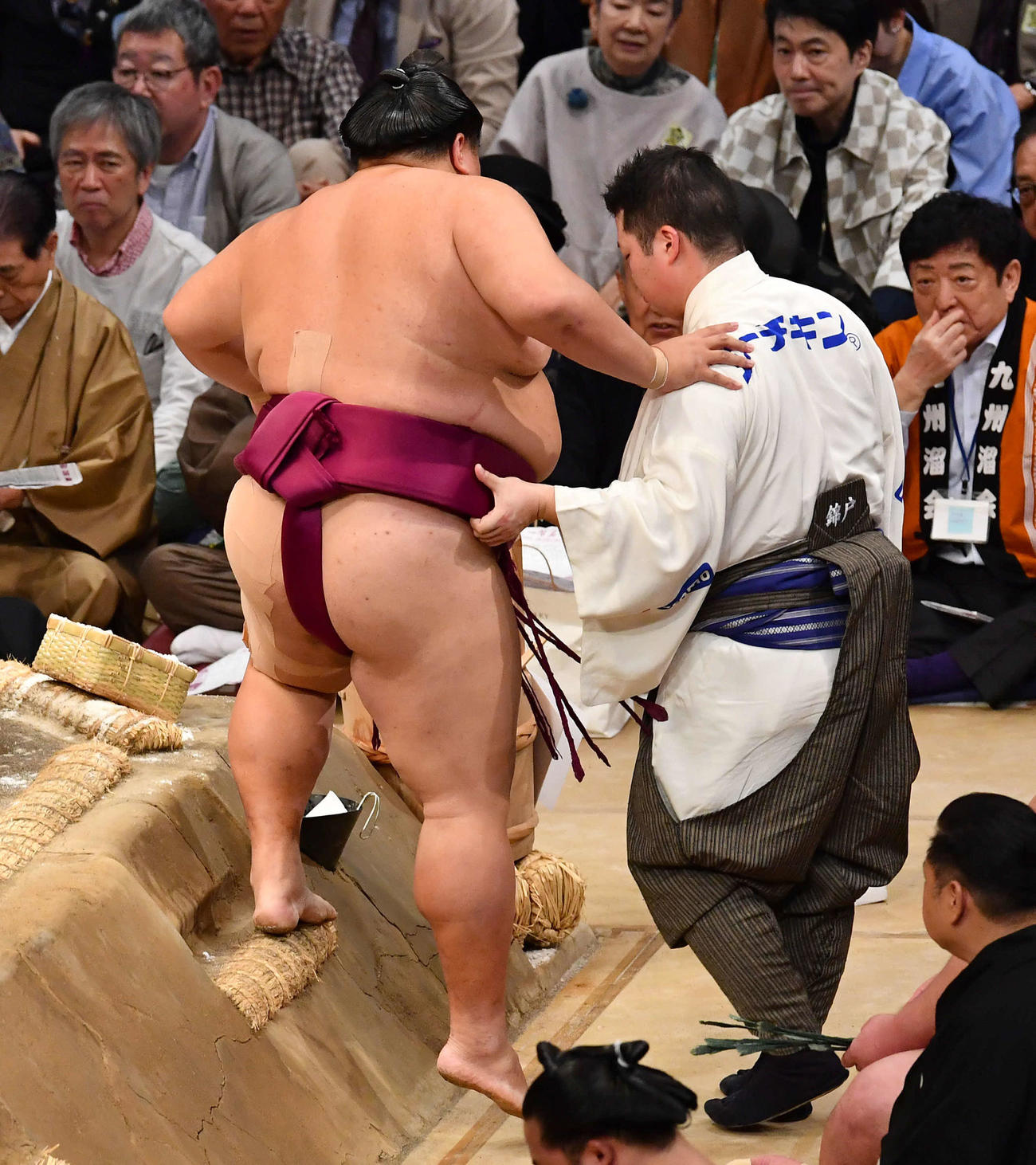 大相撲九州場所8日目　寄り切りで高安に敗れた御嶽海は、肩を借りながら土俵を下りる（撮影・岩下翔太）
