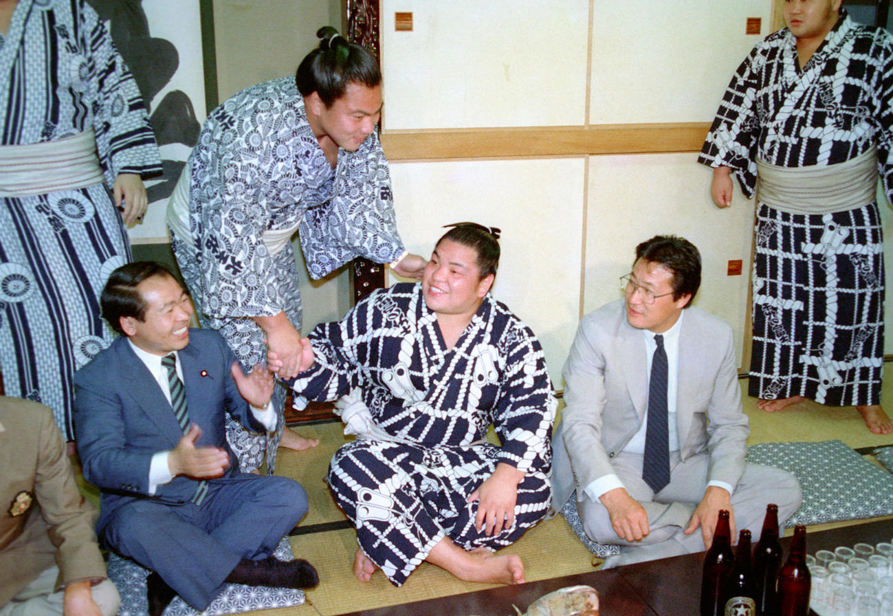 横綱審議委員会の推挙が決まり、師匠の九重親方（右＝52代横綱北の富士）、後援会長の鈴木宗男衆院議員（左）、兄弟子の横綱千代の富士（後方）から祝福を受ける北勝海（1987年5月25日　撮影）