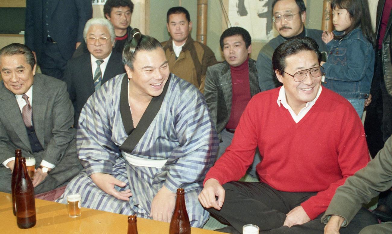 千代の富士（左）は連勝記録を53に伸ばし、千秋楽を待たずに4場所連続26度目の優勝を決め、九重親方（右＝元横綱北の富士）らの祝福を受ける（1988年11月26日撮影）