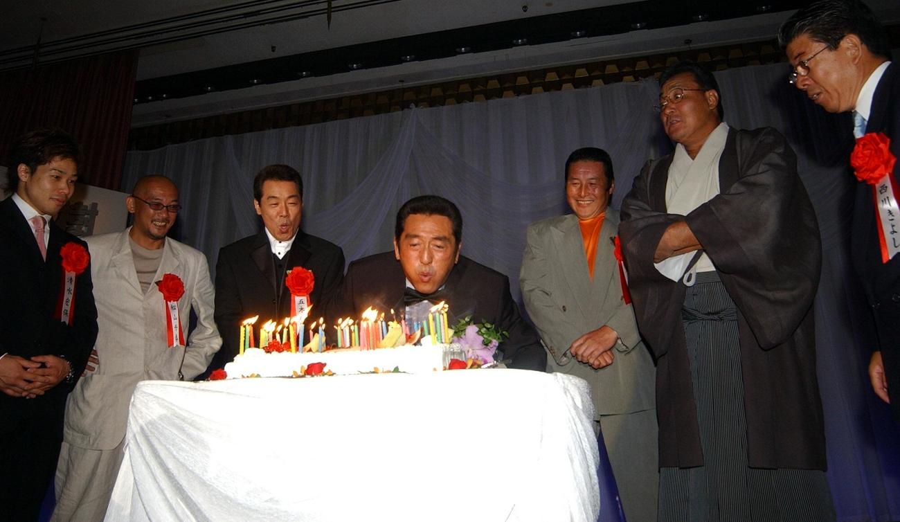 02年7月、還暦祝賀会でロウソクの火を吹き消す。後列左から清水宏保、松山千春、五木ひろし、尾崎将司、北の富士さん、西川きよし