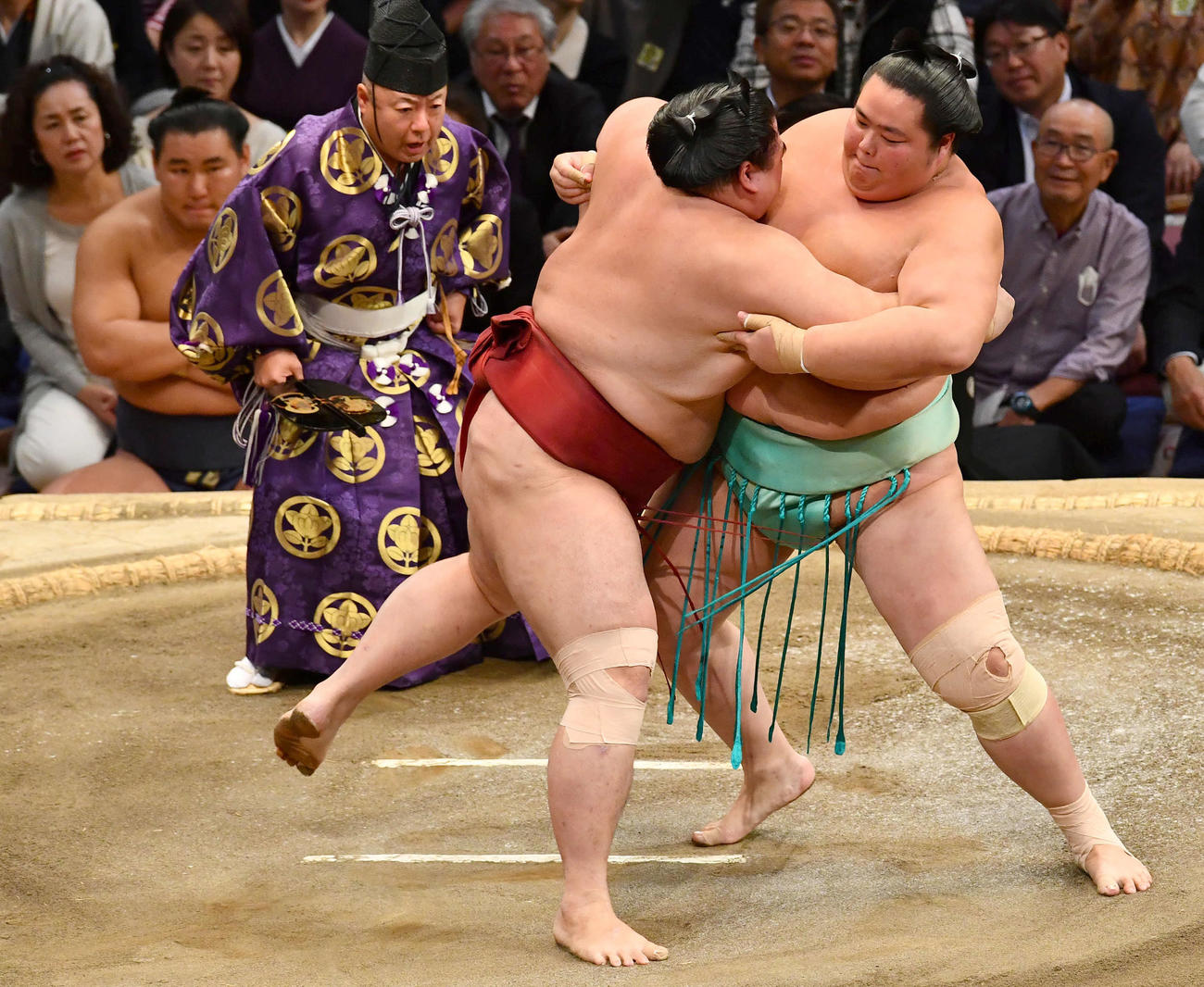大相撲九州場所13日目　土俵下から豊昇龍（左奥）が見つめる前で隆の勝（左）と組み合う琴桜（撮影・岩下翔太）