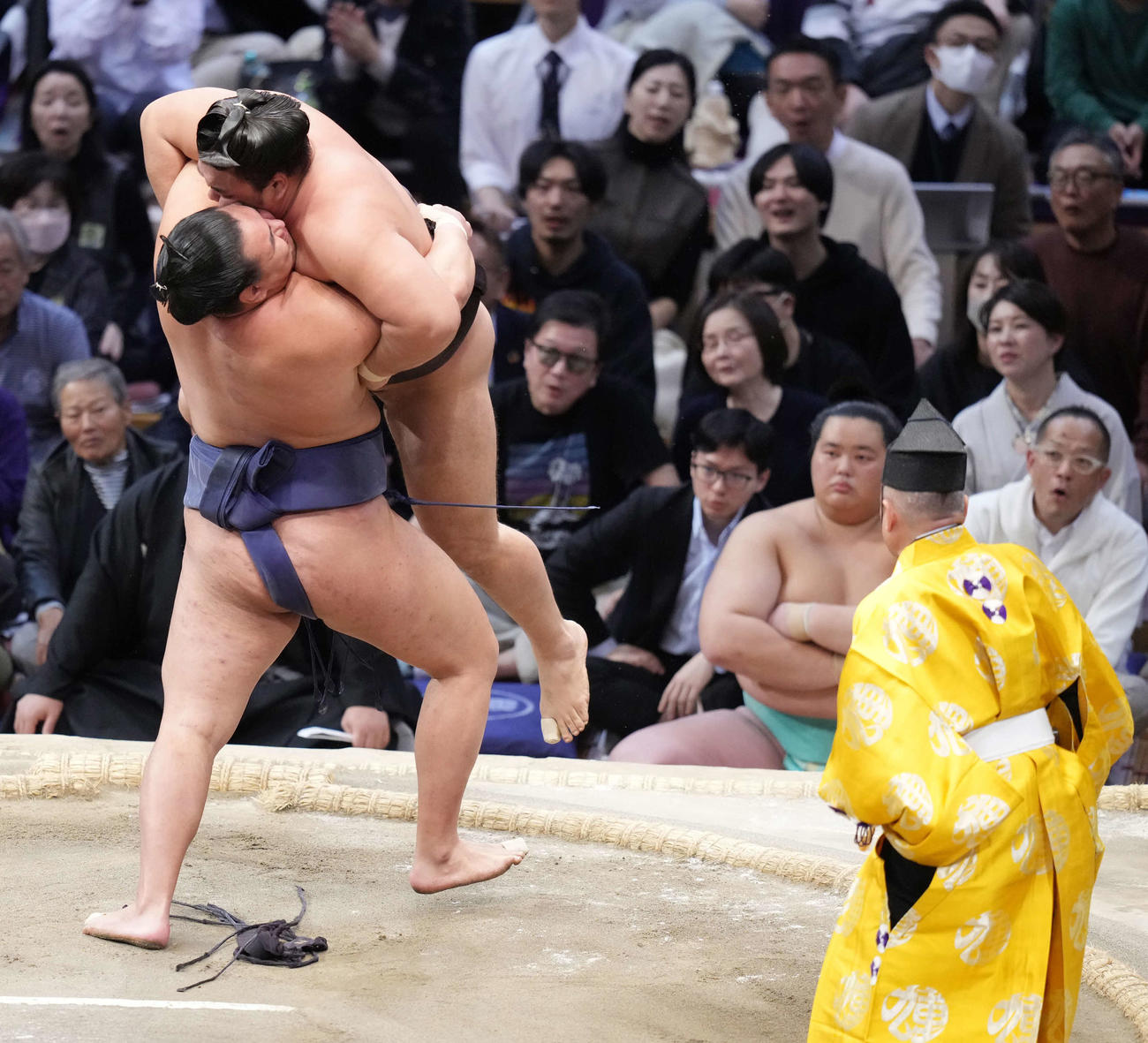 豊昇龍（左）は吊り出しで霧島を破る。右奥は1敗で並ぶ土俵下控えの琴桜（撮影・小沢裕）