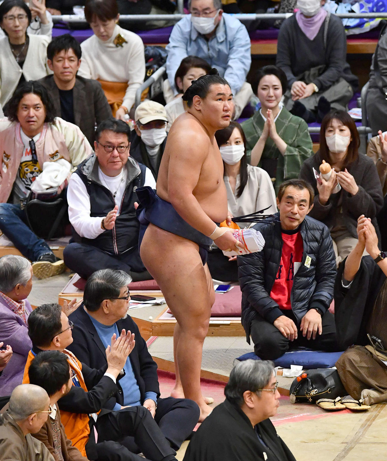 大相撲九州場所14日目　つり出しで霧島を破り、懸賞の束を手に花道を引き揚げる豊昇龍（撮影・岩下翔太）