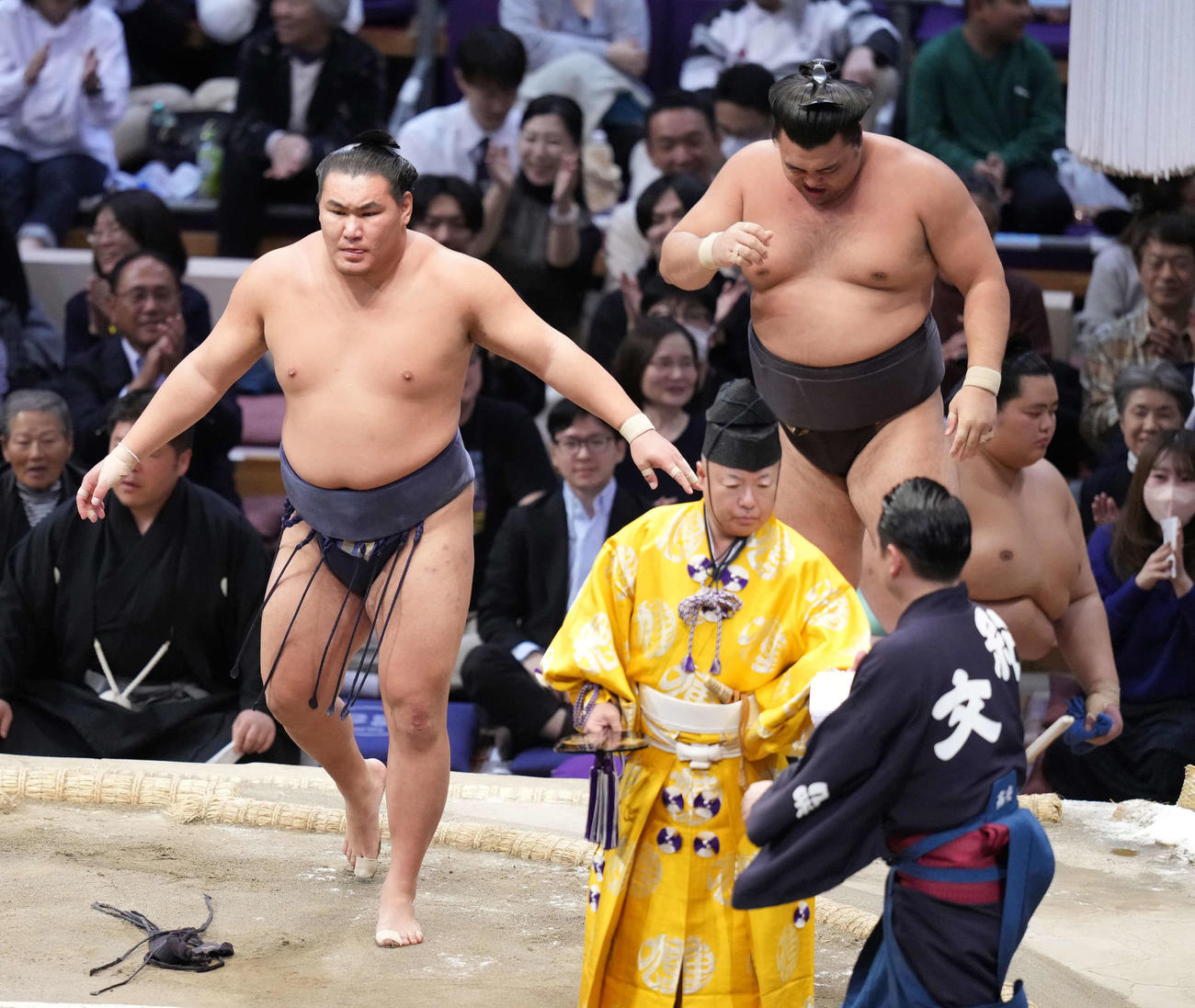 豊昇龍（左）は吊り出しで霧島を破る。右奥は1敗で並ぶ土俵下控えの琴桜（撮影・小沢裕）