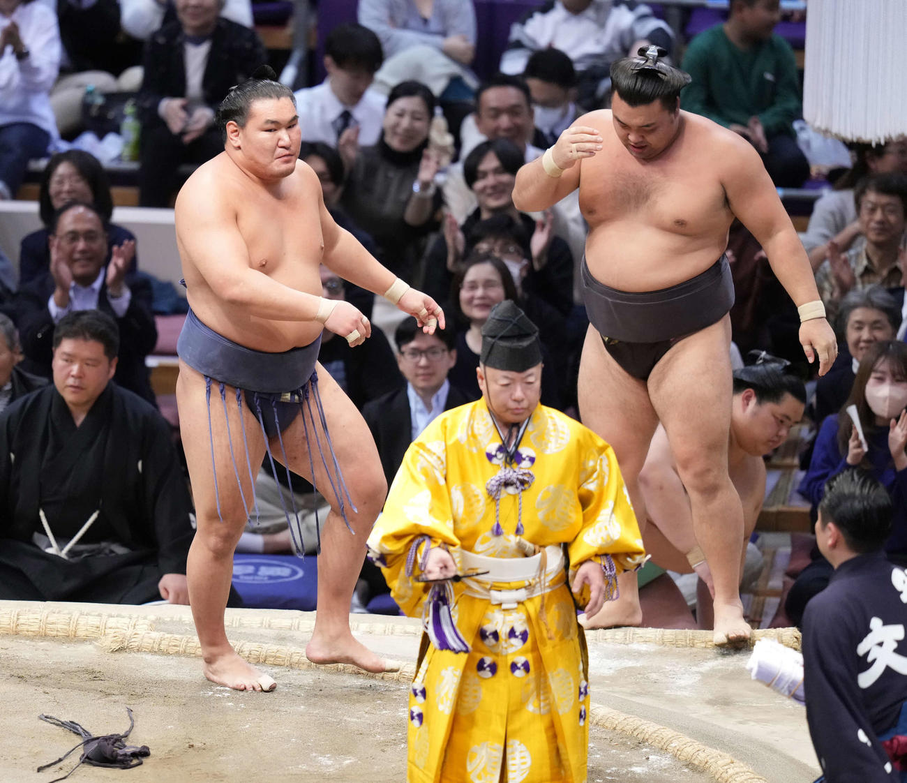 豊昇龍（左）は吊り出しで霧島を破る。右奥は1敗で並ぶ土俵下控えの琴桜（撮影・小沢裕）
