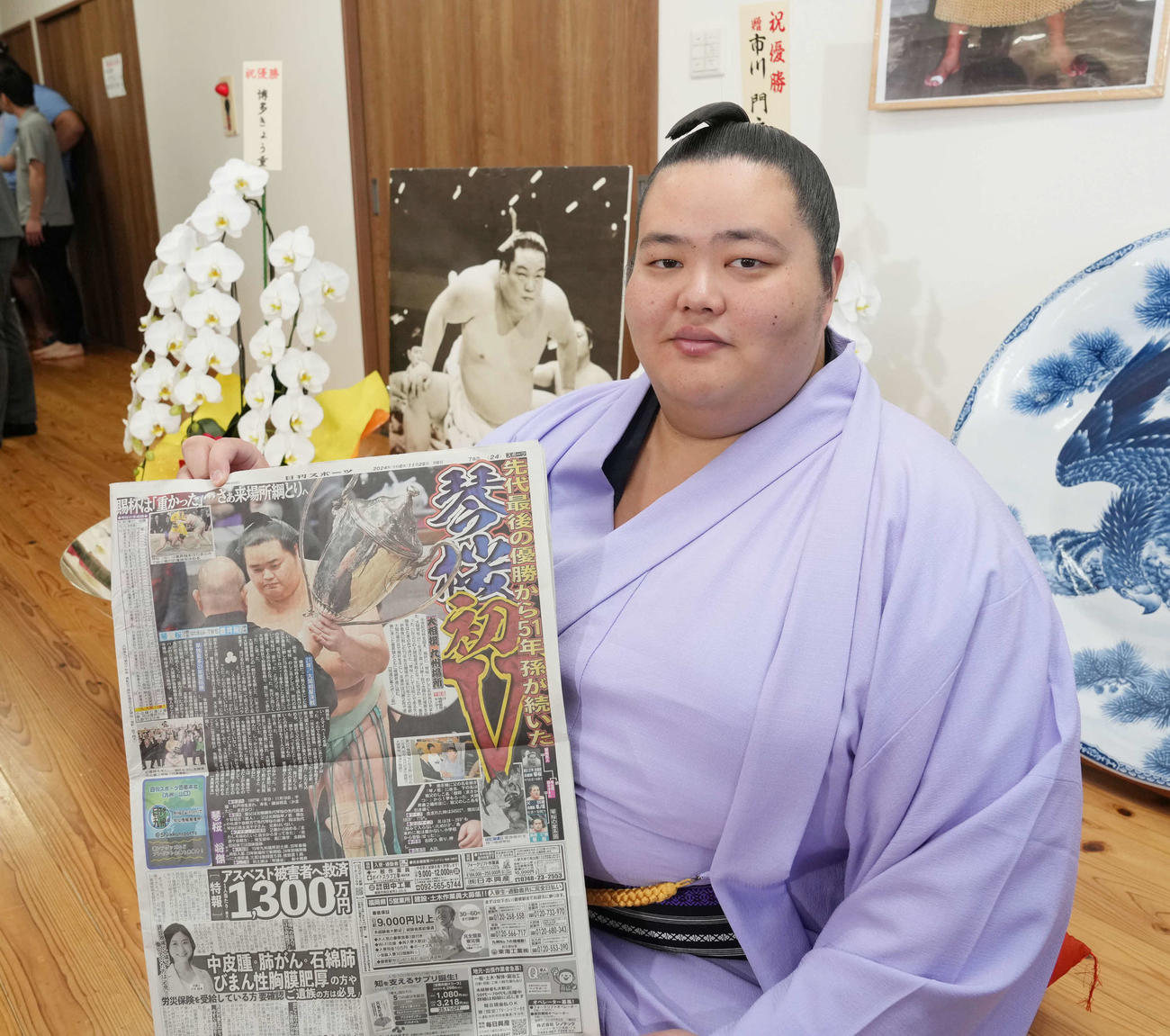 一夜明け会見で初優勝を報じた本紙を手に笑顔を見せる琴桜（撮影・小沢裕）