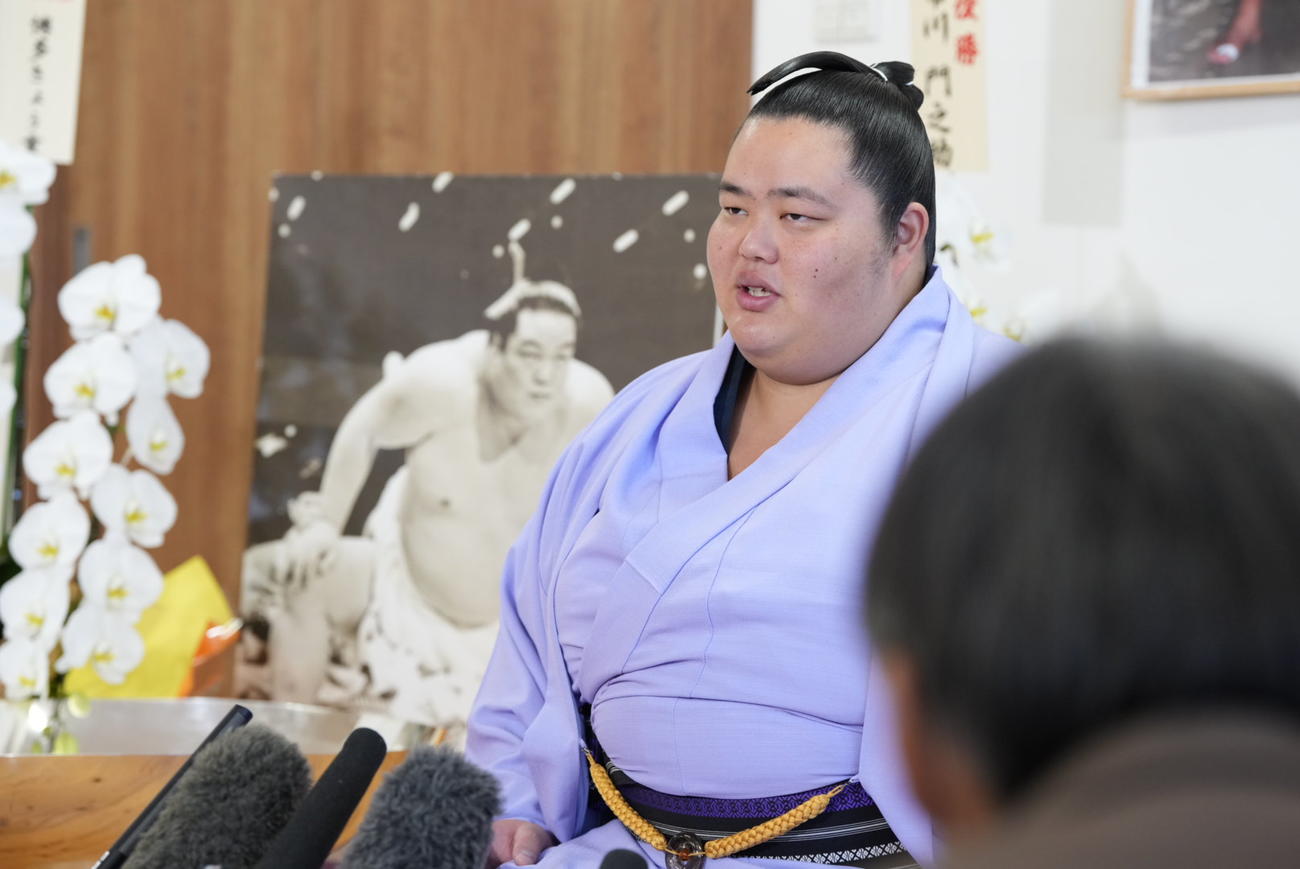 先代琴桜の写真パネルを背に優勝一夜明け会見に臨む琴桜（撮影・小沢裕）