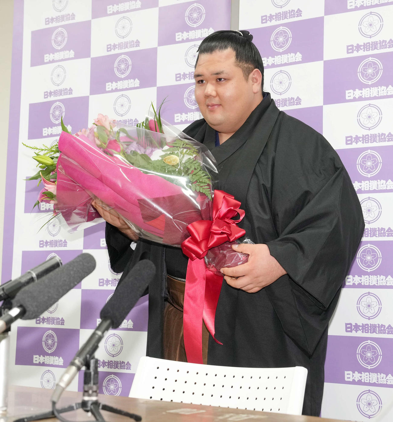 引退会見を終え花束を手に笑顔を見せる阿武咲（撮影・小沢裕）