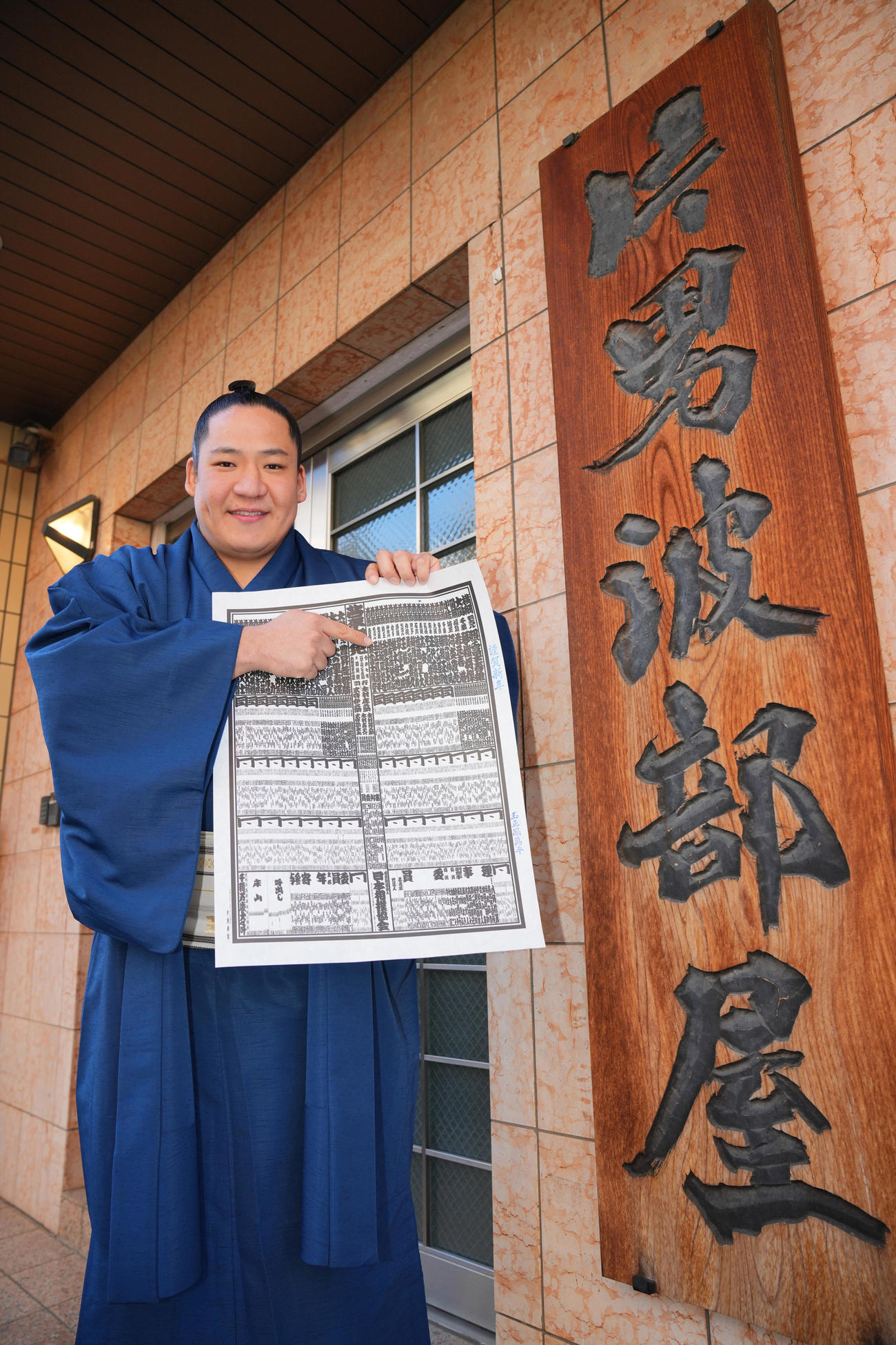 新番付表を手にしこ名を指さす新入幕の玉正鳳（撮影・垰建太）