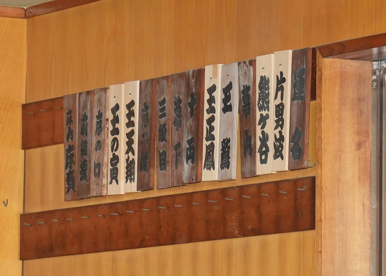 片男波部屋の稽古場に飾られた木札。手前は新入幕の玉正鳳（撮影・垰建太）