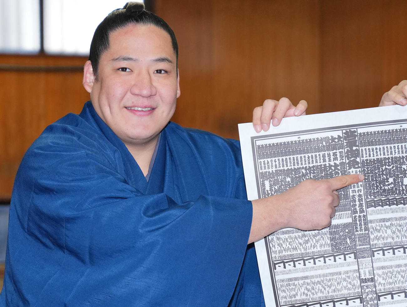 新番付表を手にしこ名を指さす新入幕の玉正鳳（撮影・垰建太）