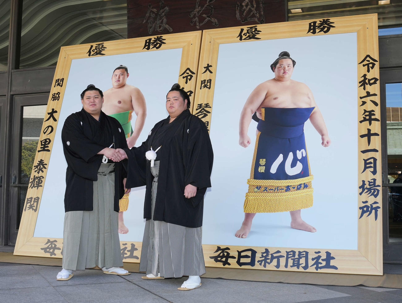 大相撲初場所の優勝額贈呈式で握手する大の里（左）と琴桜（撮影・小沢裕）