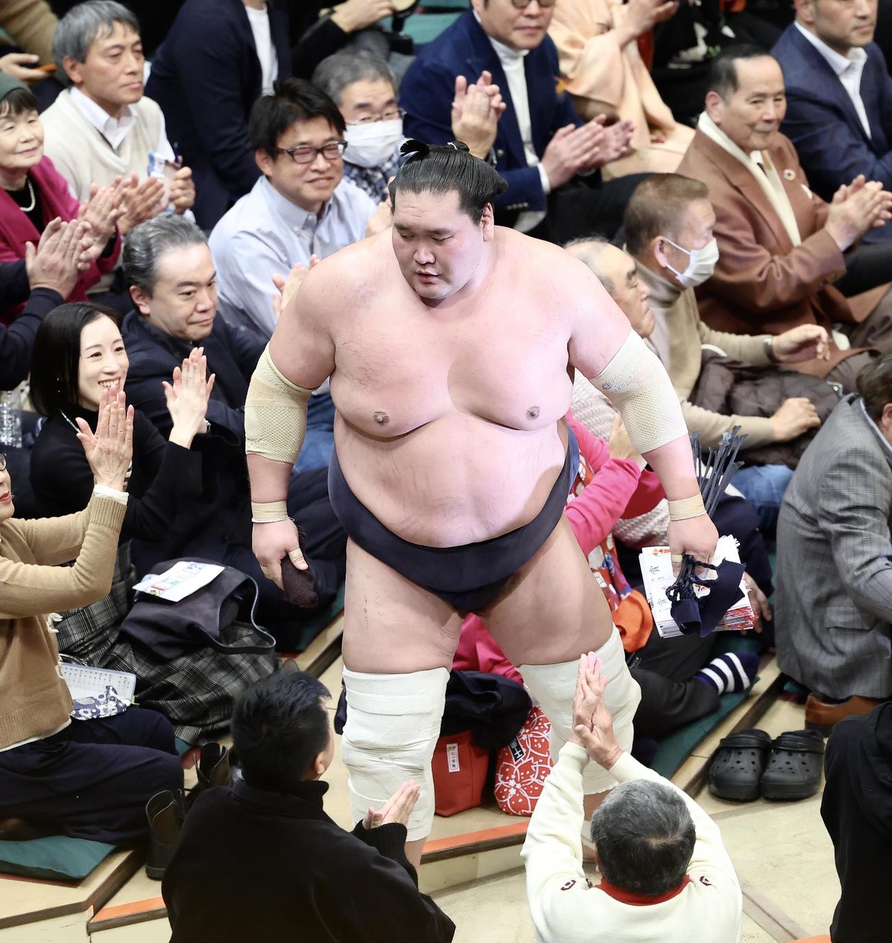 霧島（左）を寄り切りで破り、懸賞金の束を手に引き揚げる照ノ富士（撮影・河田真司）