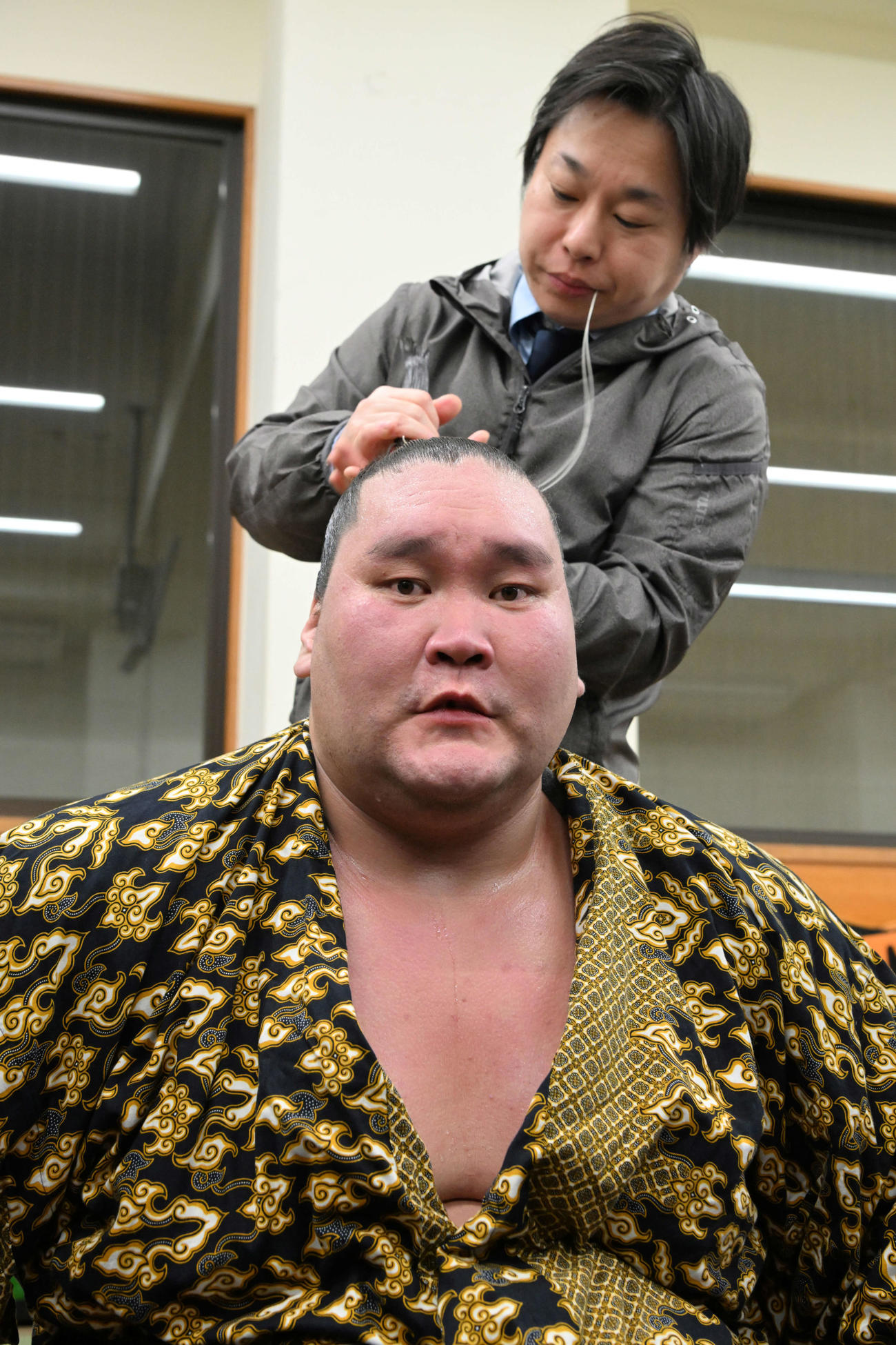 霧島との一番を終え、支度部屋でまげを結ってもらう照ノ富士