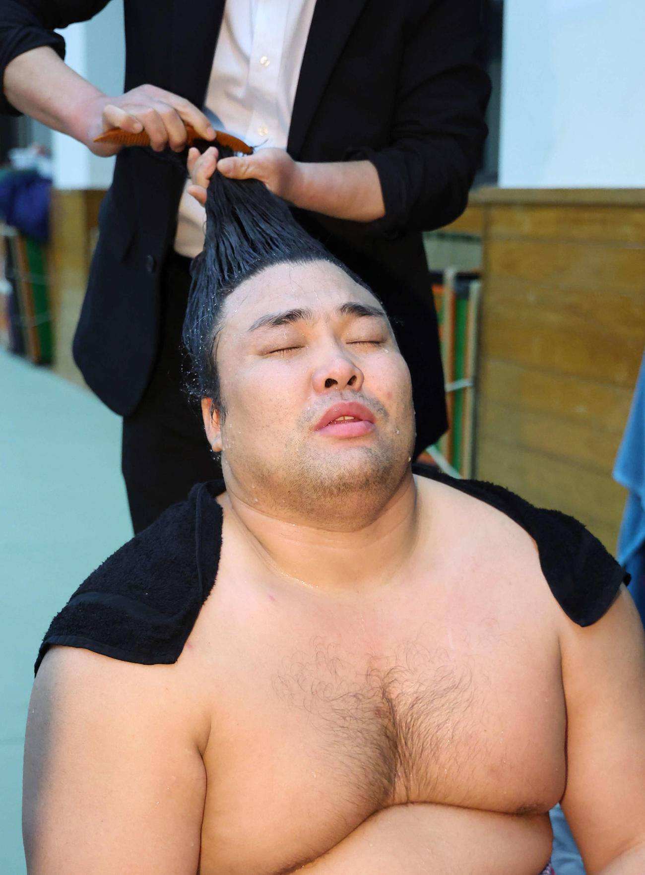 照ノ富士との一番を終え、支度部屋でまげを結ってもらう霧島
