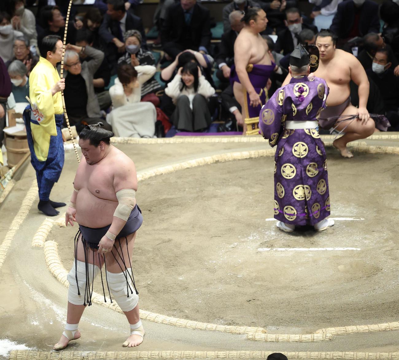 翔猿（奥）に送り出しで敗れ、土俵から引き揚げる照ノ富士（撮影・河田真司）