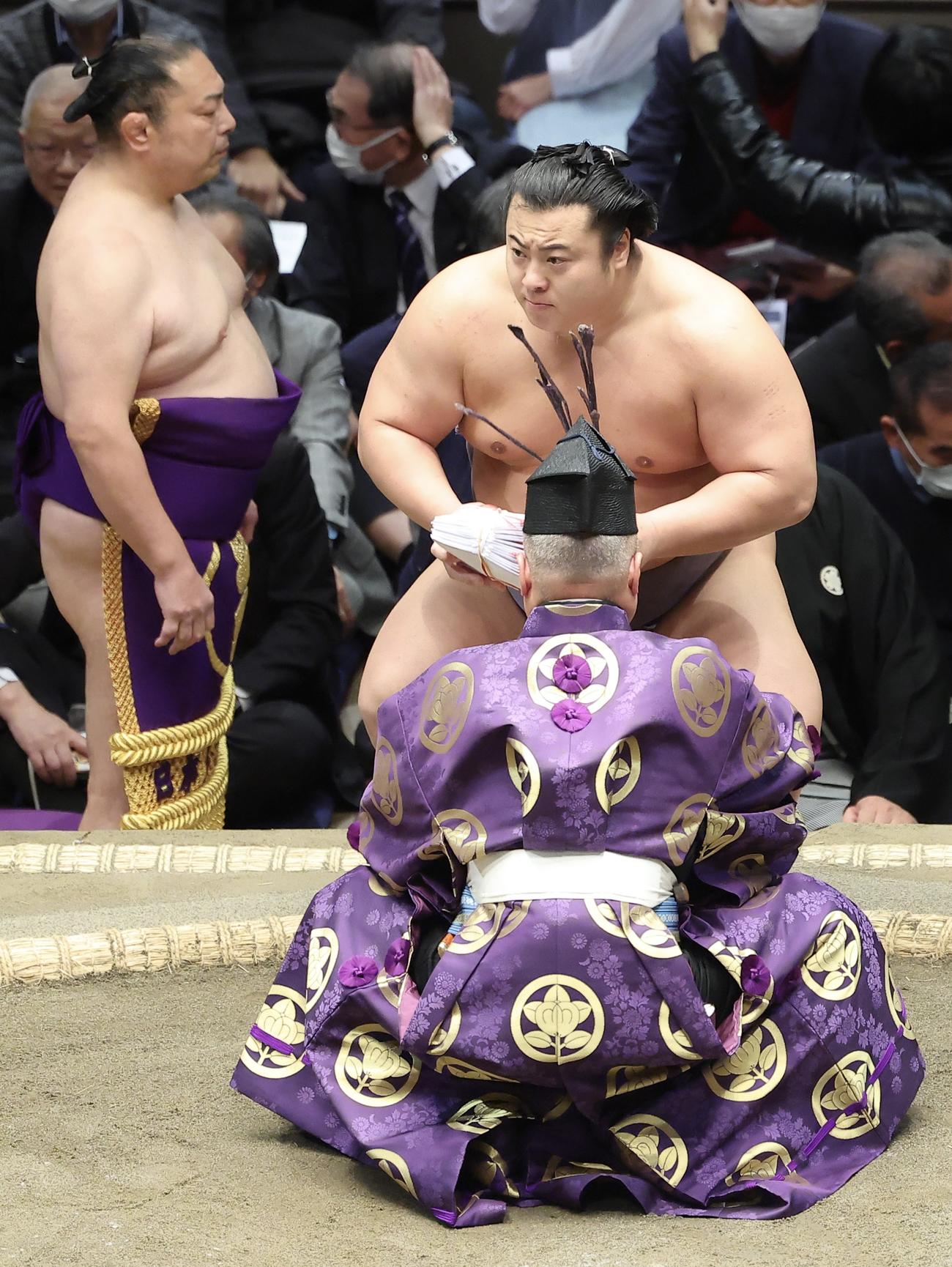 照ノ富士を送り出しで破り、懸賞金の束を手にする翔猿（撮影・河田真司）