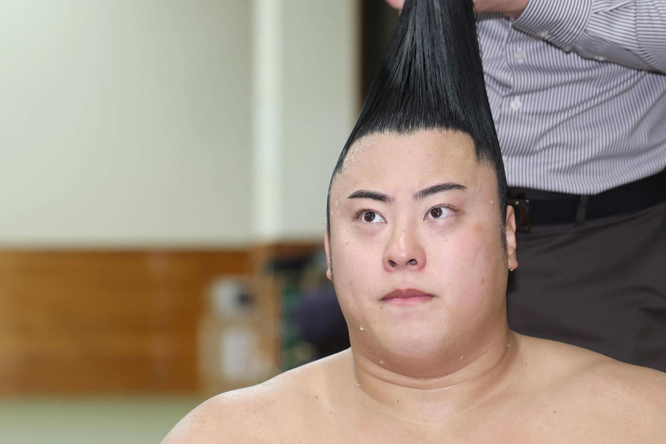 照ノ富士との一番を終え、支度部屋でまげを結ってもらう翔猿