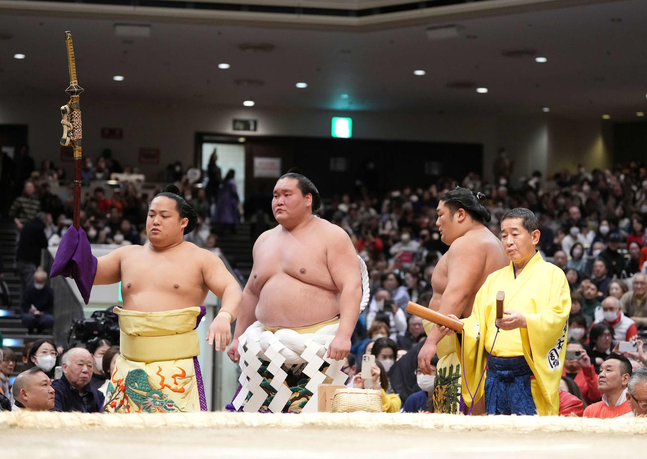 横綱土俵入りを先導する呼び出しの次郎（右）。左から太刀持ちの翠富士、照ノ富士、露払いの尊富士（2025年1月13日撮影）　